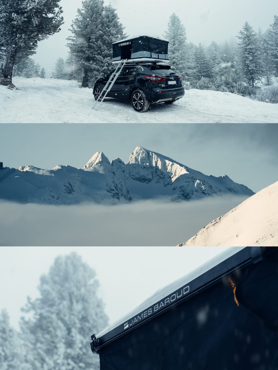 A black SUV with a roof tent is parked in a snowy forest; a mountain range rises above clouds. Travel filmmaker Filippo Bellisola captures a close-up of the James Baroud roof tent against the wintry landscape.